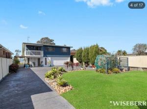 una casa con un prato verde davanti di Aircabin - Tuggerawong - Lake Front - 3 Beds House a Rocky Point