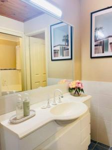 a bathroom with a sink and a mirror at Aircabin - Tuggerawong - Lake Front - 3 Beds House in Rocky Point