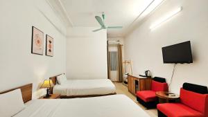 um quarto de hotel com duas camas e uma televisão em Especen Hotel em Hanói