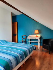 ein Schlafzimmer mit einem Bett und einem Tisch mit einer Lampe in der Unterkunft Gîte de l'école in Pontlevoy