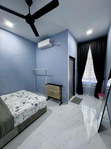 une chambre avec un lit et un ventilateur de plafond dans l'établissement Homestay D'Pusu Tiga Kuala Terengganu, à Kuala Terengganu