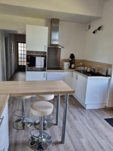 a kitchen with a wooden table and stools at Gîte du Grand frêne in Orrouy