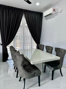 une salle à manger avec une table et des chaises en verre dans l'établissement Homestay D'Pusu Tiga Kuala Terengganu, à Kuala Terengganu