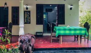 an elephant standing in front of a house with a table at Sigiriya Rock Star Home Stay in Sigiriya
