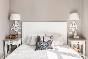 a bedroom with a white bed with two night stands at Royal penthouse, comfort and luxury in Cannes