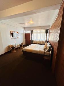 a bedroom with a bed and a window and a television at The Valaya Hotel in Darjeeling