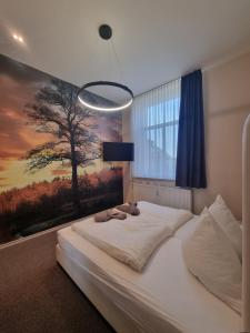um quarto com uma cama grande e uma pintura na parede em Jägerhof Putzkau em Putzkau