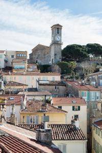 a city with a clock tower and roofs at Royal penthouse, comfort and luxury in Cannes
