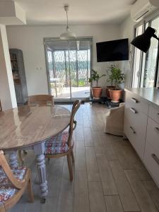 uma cozinha com mesa e cadeiras e uma televisão em Bienvenue chez Eve en bourgogne chambre 1 em Beaune