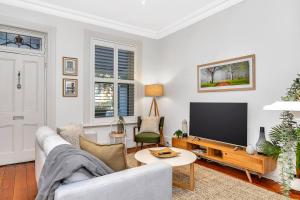 a living room with a couch and a tv at 'The Cosy Corner' Classic Haven with Modern Comforts in Adelaide