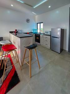 a kitchen with a refrigerator and two bar stools at Property House in Lomé