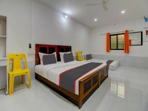 a bedroom with a large bed and a yellow stool at Homely Stays Resort in Pune
