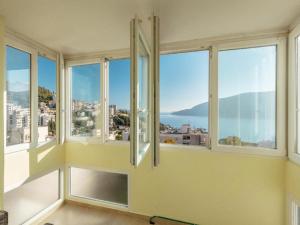 Habitación con ventanas y vistas a la ciudad. en Apartment Petit Jolie en Herceg-Novi