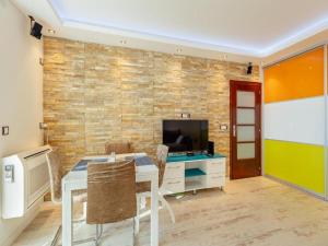 a dining room with a table and a television at Apartment Petit Jolie in Herceg-Novi