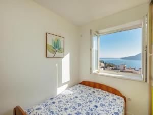 1 dormitorio con cama y ventana grande en Apartment Petit Jolie, en Herceg-Novi