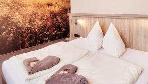 - un lit blanc avec 2 oreillers et des serviettes dans l'établissement Jägerhof Putzkau, à Putzkau