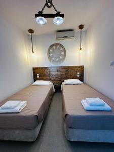 two beds sitting in a room with two lights at Elenis Studios&Apartments in Masouri