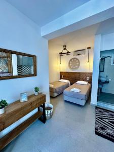 a living room with two beds and a mirror at Elenis Studios&Apartments in Masouri