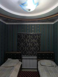KyzyldzharにあるDOM V CHIMGANEの天井の客室のベッド2台
