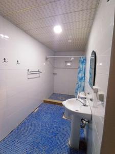 a bathroom with a white sink and a blue tile floor at DOM V CHIMGANE in Kyzyldzhar