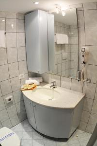 een badkamer met een wastafel, een spiegel en een toilet bij Petros Italos in Neos Marmaras
