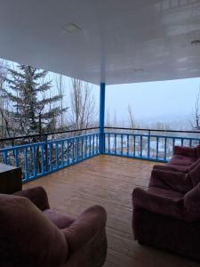 a living room with two couches on a balcony at DOM V CHIMGANE in Kyzyldzhar
