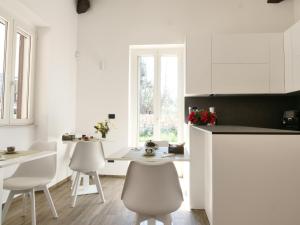 a white kitchen with white chairs and a table at Murgia Holiday in Terlizzi