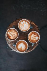 quatro chávenas de café numa mesa de madeira em Nice and cozy appartment Innside photos are coming soon em Dogliani