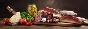 uma tábua de corte com diferentes tipos de carnes e produtos hortícolas em Nice and cozy appartment Innside photos are coming soon em Dogliani