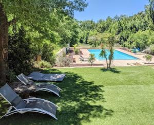 un cortile con 2 sedie e una piscina di MAS # PISCINE OLIVERAIE RUISSEAU CHEVAUX # SALAGOU a Lacoste