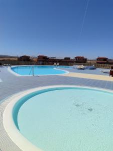 ein großes Schwimmbecken mit blauem Wasser in der Unterkunft Casa del Amanecer in Lajares