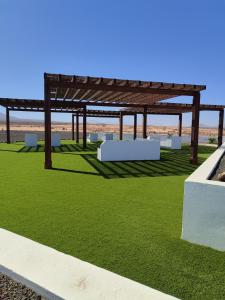 einem Pavillon mit grünem Gras und einer Holzkonstruktion in der Unterkunft Casa del Amanecer in Lajares