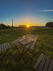 - une table de pique-nique dans un champ avec le coucher du soleil en arrière-plan dans l'établissement La Prairie Drômoise - Aux portes de Montélimar, à Châteauneuf-du-Rhône