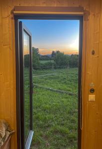 une porte offrant une vue sur un champ depuis une fenêtre dans l'établissement La Prairie Drômoise - Aux portes de Montélimar, à Châteauneuf-du-Rhône