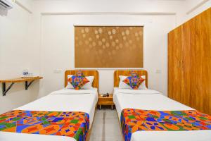 a room with two beds and a window at FabHotel Prime Esta Inn in Pune