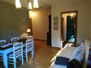 a living room with a table and a dining room at spazioso trilocale in Cesana Torinese