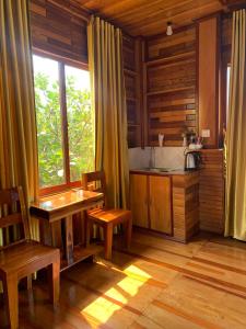 kuchnia ze stołem i krzesłami oraz oknem w obiekcie Samnang Leap guesthouse w mieście Sen Monorom