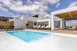 a villa with a swimming pool and a house at Finca el Rincón de Lanzarote in Tías