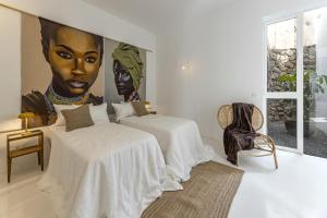 two beds in a room with a large painting on the wall at Finca el Rincón de Lanzarote in Tías