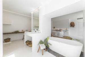 a white bathroom with a tub and a bedroom at Finca el Rincón de Lanzarote in Tías +45 photos