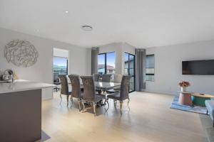 a kitchen and dining room with a table and chairs at Stunning Luxe Home Near Airport in Auckland