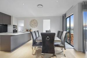 a kitchen and dining room with a table and chairs at Stunning Luxe Home Near Airport in Auckland