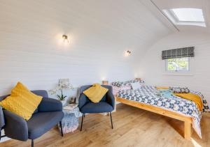 a bedroom with a bed and two chairs at Corris in Cyffylliog