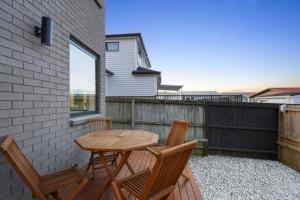 d'une terrasse avec une table en bois et 2 chaises. dans l'établissement Stunning Luxe Home Near Airport, à Auckland