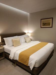 a bedroom with a large bed with two pillows at Caliraya Mountain Lake Resort in Cavinti