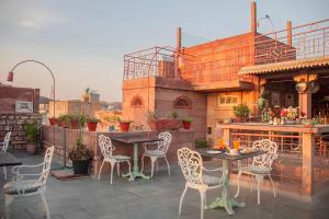 a patio with chairs and a table and a bar at Amritara Manak Haveli, Jodhpur in Jodhpur