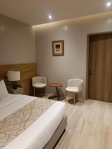 CavintiにあるCaliraya Mountain Lake Resortのベッドルーム1室(ベッド1台、椅子2脚、テーブル付)
