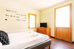 a bedroom with a bed and a tv on a wall at Residenza Alle Fonti palazzo del 1886 nel cuore di Vittorio Veneto in Vittorio Veneto +66 photos