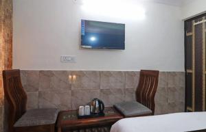 Et tv og/eller underholdning på Roomshala 172 Hotel Blue Moon - Satya Niketan