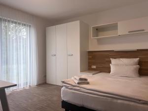 a bedroom with a large bed and a large window at NewAge Boardinghaus P5 in Heilbronn
